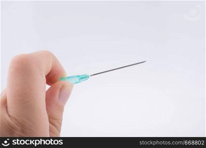 Hand holding an syringe over a white background