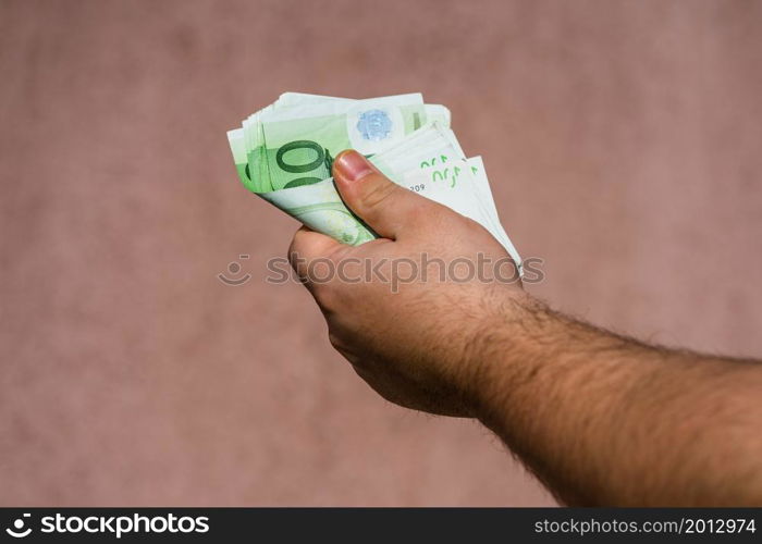 Hand holding and showing euro money or giving money. World money concept, 100 EURO banknotes EUR currency isolated. Concept of rich business people, saving or spending money.