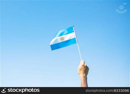 hand holding Argentina flag on nature background. 9th July of Independence day, 25th May of Revolution day and happy celebration concepts