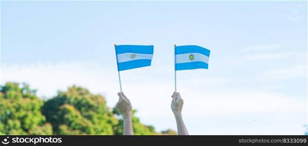 hand holding Argentina flag on nature background. 9th July of Independence day, 25th May of Revolution day and happy celebration concepts