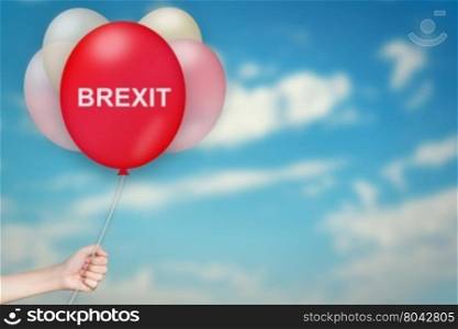 Hand Holding BREXIT or British Exit Balloon with sky blurred background