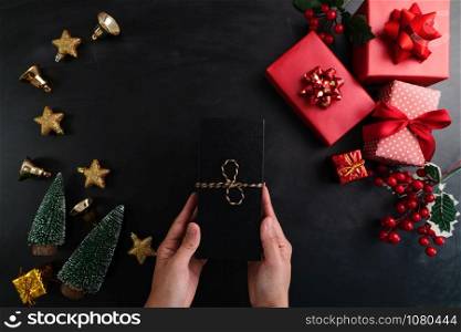 Hand holding christmas present in xmas decoration background