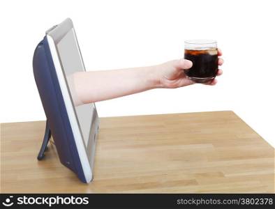 hand holding cola with ice in glass leans out TV screen isolated on white background