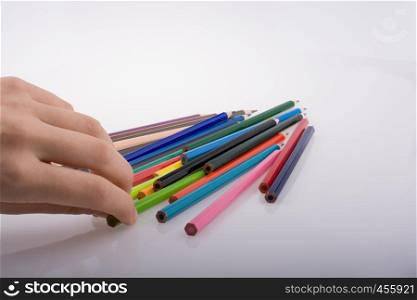 Hand holding color pencils on a white background