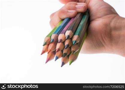 Hand holding color pencils on a white background