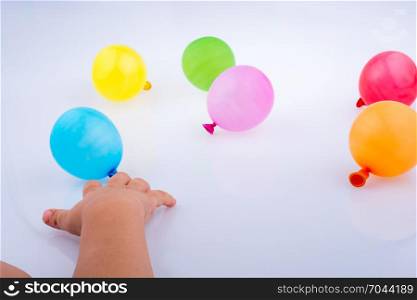 Hand holding colorful balloons on a white background