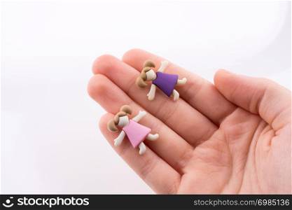 Hand holding colorful dressed children figures on a white background
