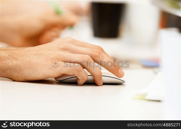 Hand holding computer mouse. Hands of office worker holding computer mouse