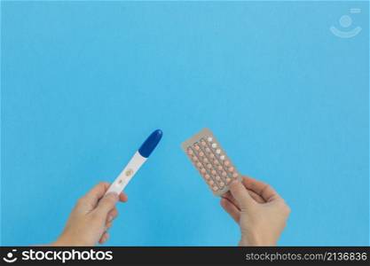 hand holding contraceptive pills pregnancy test