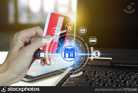 Hand holding credit card and using laptop with online shopping icons technology, Online shopping concept