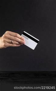 hand holding credit card black background