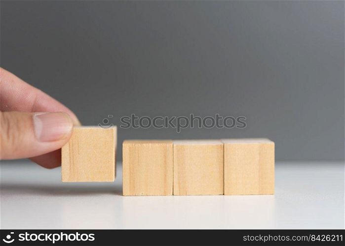 hand holding cube wood block blank on background. copy space