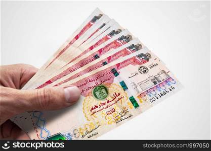 Hand holding dirhams of United Arab Emiratess. AED. Currency of UAE.. Hand holding dirhams of United Arab Emiratess. AED. Currency of UAE