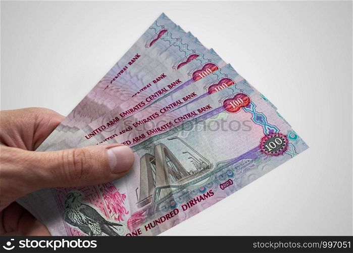 Hand holding dirhams of United Arab Emiratess. AED. Currency of UAE.. Hand holding dirhams of United Arab Emiratess. AED. Currency of UAE