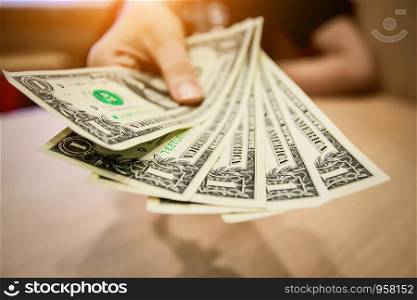 Hand holding dollar for pay or buy product at supermarket,Money for everyday shopping and Investment for saving concept