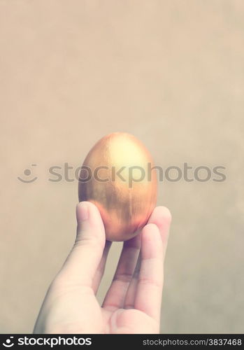 Hand holding easter egg with retro filter effect