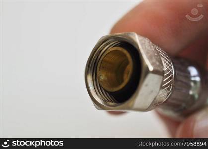 Hand holding faucet connector on white background