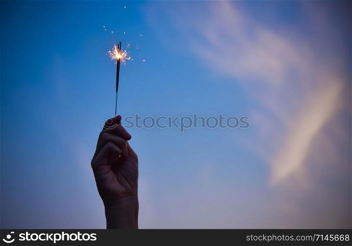 Hand holding firework on Sky evening celebration Merry Christmas and Happy new year night party
