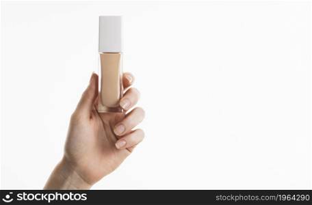hand holding foundation bottle with copy space. High resolution photo. hand holding foundation bottle with copy space. High quality photo