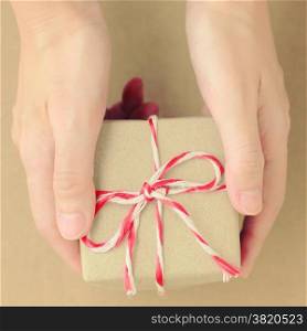 Hand holding gift box with retro filter effect