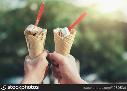 hand holding ice cream cone in morning light