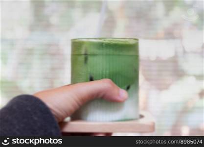 Hand holding iced matcha greentea, stock photo