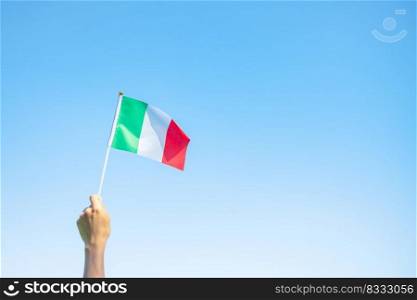 hand holding Italy flag on nature background. National Day, Republic Day, Festa della Repubblica and happy celebration concepts