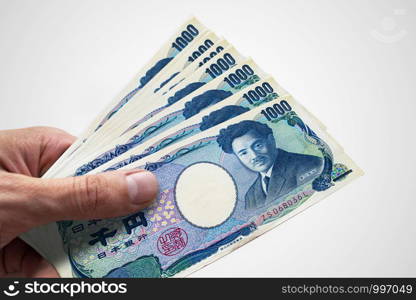 Hand holding Japanese Yens.. JPY. Currency of Japan.. Hand holding Japanese Yens.. JPY. Currency of Japan