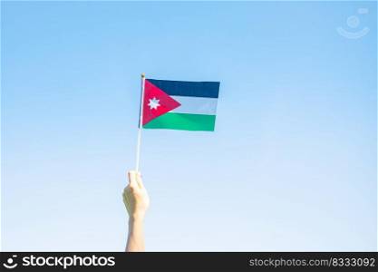 hand holding Jordan flag on nature background. Jordan Independence day and happy celebration concepts