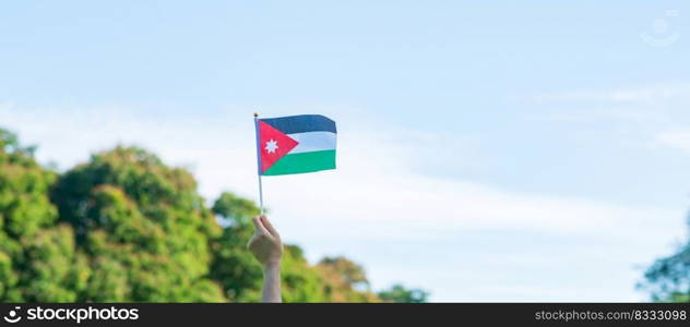 hand holding Jordan flag on nature background. Jordan Independence day and happy celebration concepts