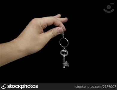 Hand holding key isolated on black background