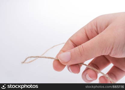 Hand holding linen thread on a white background