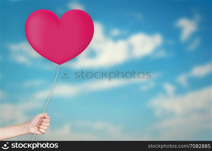Hand Holding love Balloon with sky blurred background