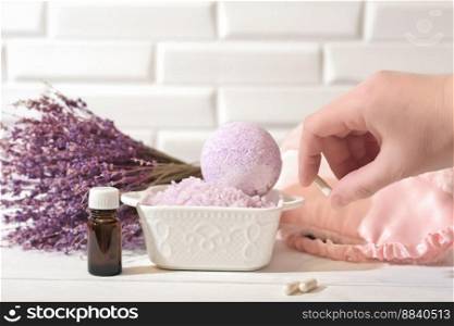 hand holding Melatonin capsules. Relaxing bath salt and bath bomb with lavender oil. Lavender as calming and soothing ingredient for good sleep. insomnia support. hand holding Melatonin capsules. Relaxing bath salt and bath bomb with lavender oil. Lavender as calming and soothing ingredient for good sleep. insomnia support. 