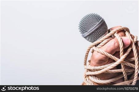 Hand holding microphone and have roped on fist hand on white background, Human rights day concept