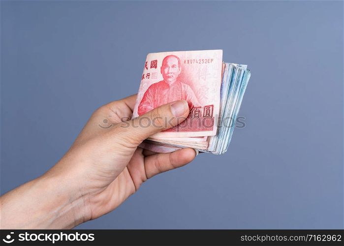 hand holding New Taiwan Dollar banknote, Cash