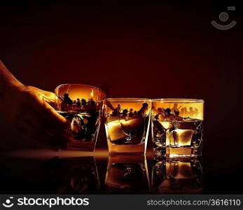 Hand holding one of three glasses of whiskey with ice and party illustration in