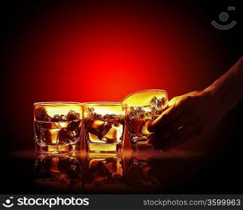 Hand holding one of three glasses of whiskey with nature illustration in