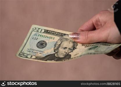 Hand holding or giving dollars money. Holding US dollars banknote on a blurred background, US currency