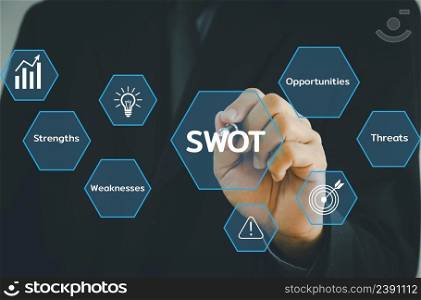 Hand holding pen businessman icon SWOT strengths weaknesses opportunities threats virtual screen.Business marketing Concept.
