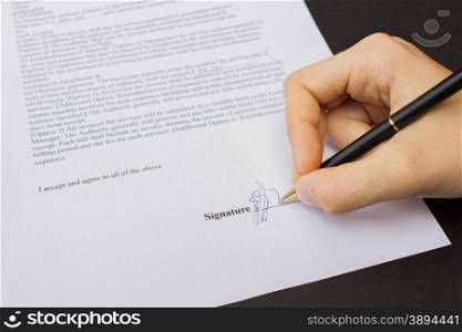 hand holding pen signing a contract