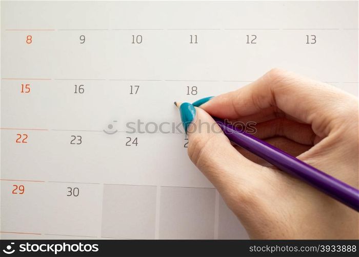 hand holding pencil on calendar for making appointment important day