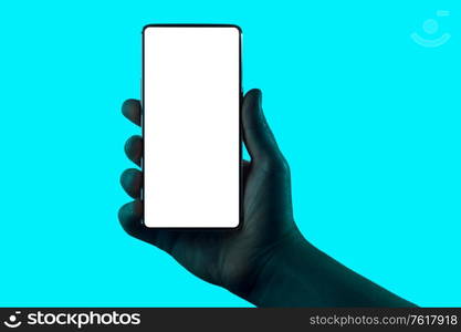 Hand holding phone. Silhouette of male hand holding smartphone isolated on aqua blue background. Bezel-less screen is cut with clipping path.. Hand holding phone.