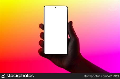 Hand holding phone. Silhouette of male hand holding smartphone isolated on multicolored background. Bezel-less screen is cut with clipping path.. Hand holding phone.