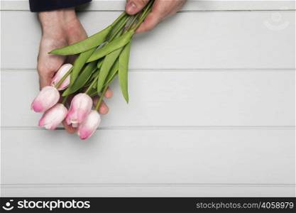 hand holding pink tulips bouquet