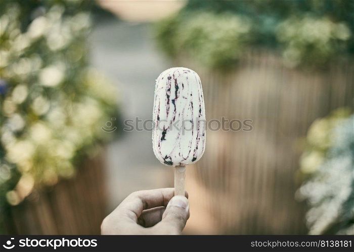 Hand holding popsicle on background. 