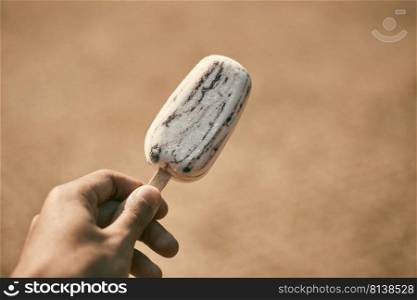 Hand holding popsicle on background. 