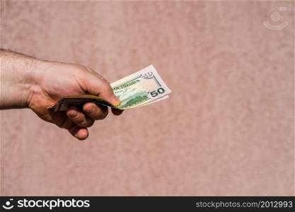 Hand holding showing dollars money and giving or receiving money like tips, salary. 50 USD banknotes, American Dollars currency isolated with copy space.