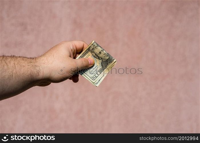 Hand holding showing dollars money and giving or receiving money like tips, salary. 20 USD banknotes, American Dollars currency isolated with copy space.
