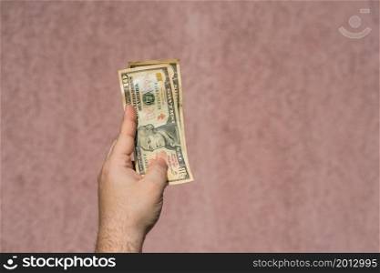 Hand holding showing dollars money and giving or receiving money like tips, salary. 10 USD banknotes, American Dollars currency isolated with copy space.